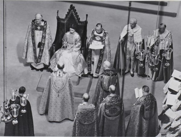 The Archbishop presents the Queen with the Sword of State while she sits on the throne in Westminster Abbey